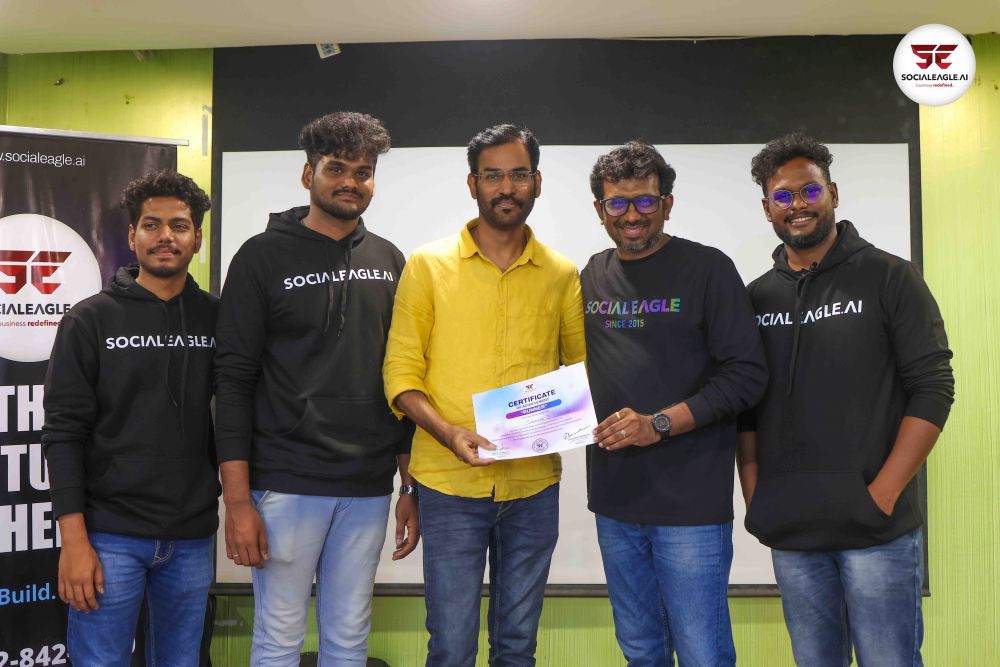 Two men collaborating over laptops in workshop setting