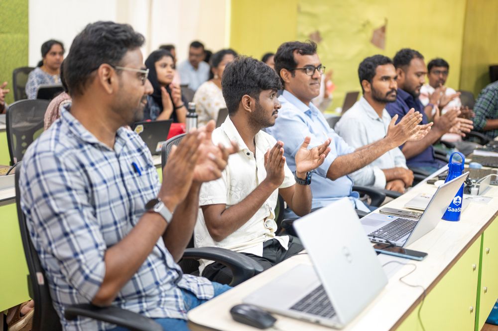 Woman in LIVE FOR THE COMMUNITY t-shirt talking to man in hoodie